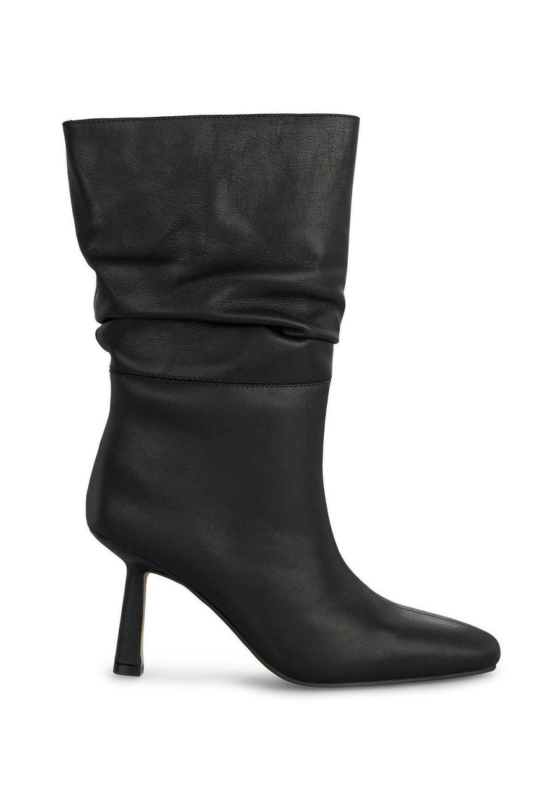 Czarne skórzane botki za kostkę o luźnym kroju, ze spiczastym noskiem i smukłym obcasem typu stiletto. Gładka tekstura z minimalistycznymi akcentami.