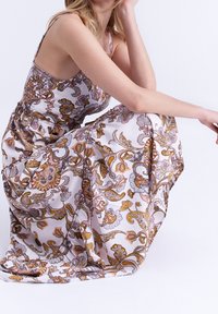 Robe longue à motif floral en tissu léger, dotée d'un corsage ajusté, de bretelles spaghetti et d'une jupe fluide aux couleurs vives.