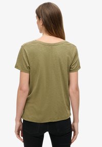 Olivegrøn kortærmet T-shirt med rund halsudskæring. Blød tekstur og en afslappet pasform, der har diskrete sømdetaljer i ryggen.