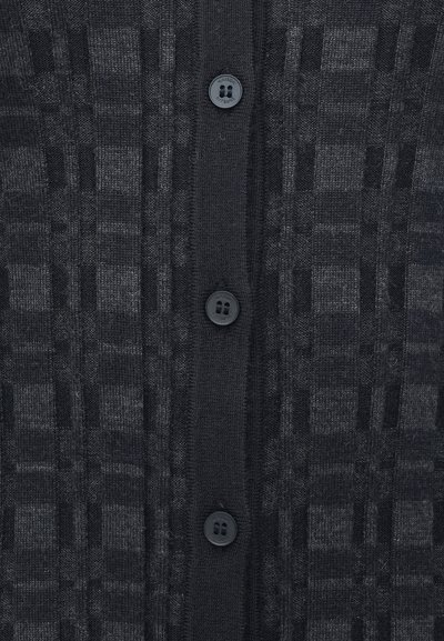 Cardigan negru tricotat, cu un model texturat în carouri, dotat cu închidere cu butoane în față și patru butoane negre pe centrul produsului.