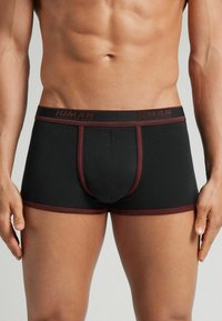 Boxer ajustados en color negro. Presentan costuras de acento en burdeos y una cinturilla con marca. Fabricados con material elástico para mayor comodidad.