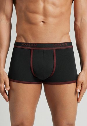 Boxer ajustados en color negro. Presentan costuras de acento en burdeos y una cinturilla con marca. Fabricados con material elástico para mayor comodidad.