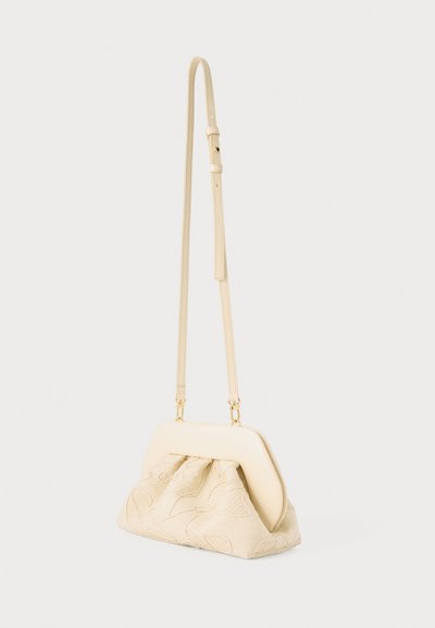 Μικρό μπεζ τσάντα ώμου με ρυθμιζόμενο λεπτό λουρί και μαλακό ύφασμα που διαθέτει διακριτική κεντητή λουλουδιών.