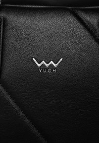 Schwarzes strukturiertes Material mit einem glänzenden silbernen VUCH-Logo. Verfügt über kantige Nähte und eine glatte Oberfläche, die die Schlichtheit des Designs betont.