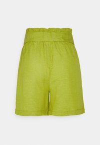 Shorts en lin vert avec une taille haute à volants et des poches latérales. Présentent une coupe décontractée et des revers roulés à l'ourlet.