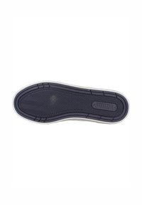 Suela de zapato con un patrón de zigzag negro, bordeado por un borde de goma blanca. Superficie lisa con forma redondeada y ligera elevación.