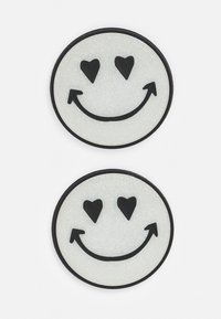 Duas manchas redondas e brilhantes em branco com um sorriso, com detalhes em preto, apresentando olhos em forma de coração e um sorriso curvado.
