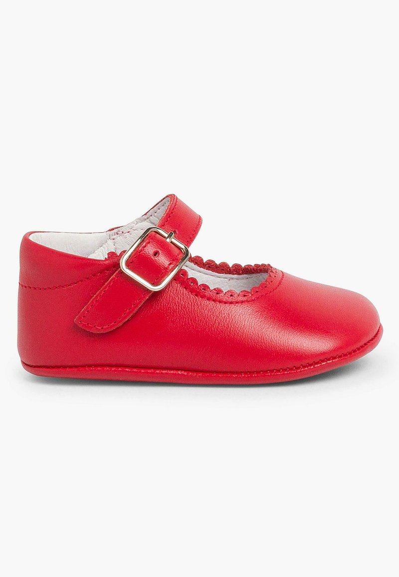 Zapato Mary Jane de cuero rojo con diseño de recortes ondulados, cierre de hebilla y puntera redonda. Textura suave con suela plana.