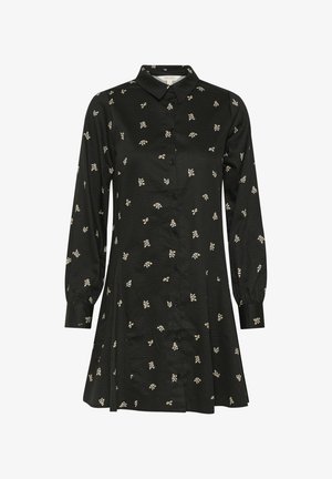 Mustmusterdress, millel pikkade varrukatega, tekstuurne kangas ja väikesed lillemustrid valge ja heleda kollasega üle kogu aluse.