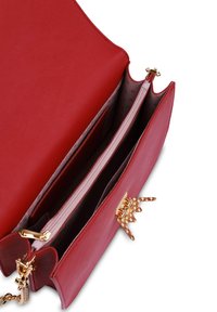 Červená kožená kabelka s dvojitými přihrádkami, zlatými prvky a texturovaným uzávěrem. Interiér má dvoubarevný puntíkovaný vzor a zipovou kapsu.