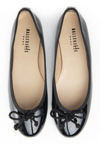 Schwarze Lackleder-Ballerinas mit schwarzem elastischem Rand und einer gedrehten Seil-Schleifenverzierung vorne. Ausgefüttertes Innere mit Markenname.