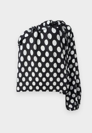 Black and white polka dot top with one long sleeve, gathered neckline, and textured fabric. Features large white circles on a black background.