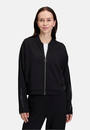 Black cropped bomber jacket with a zip front, ribbed hem, and satin-like sleeve accents. Features decorative mesh detailing on the sides.