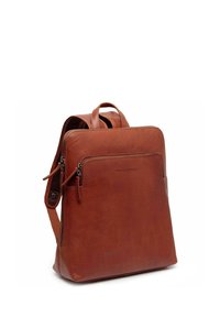 Sac à dos en cuir marron au design simple, comprenant un compartiment principal, une poche zippée à l'avant et deux poignées supérieures pour un transport facile.