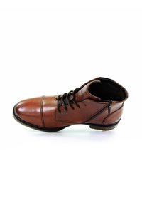 Bottine en cuir marron avec un bout arrondi, un laçage, une fermeture éclair sur le côté et de subtils détails de couture. Texture lisse et semelle robuste.