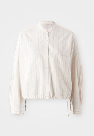 Camicia bianca con bottoni, caratterizzata da sottili righe verticali, colletto arrotondato, due tasche frontali e orlo elasticizzato con cordoncini. Tessuto morbido.
