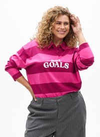 Long-sleeve polo shirt with horizontal pink stripes in varying shades, featuring a white text graphic "NO1 GOALS" on the front.