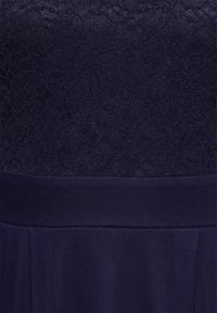 Granatowa sukienka z koronkowym gorsetem w kwiaty oraz gładką, plisowaną spódnicą, z teksturowanym pasem dla dodatkowego efektu wizualnego.