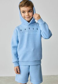 Jasnoniebieski zestaw z kapturem i szortami. Hoodie ma teksturowany wzór i logo, z kapturem na sznurki i ściągaczami przy mankietach.