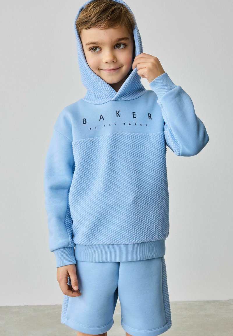 Jasnoniebieski zestaw z kapturem i szortami. Hoodie ma teksturowany wzór i logo, z kapturem na sznurki i ściągaczami przy mankietach.