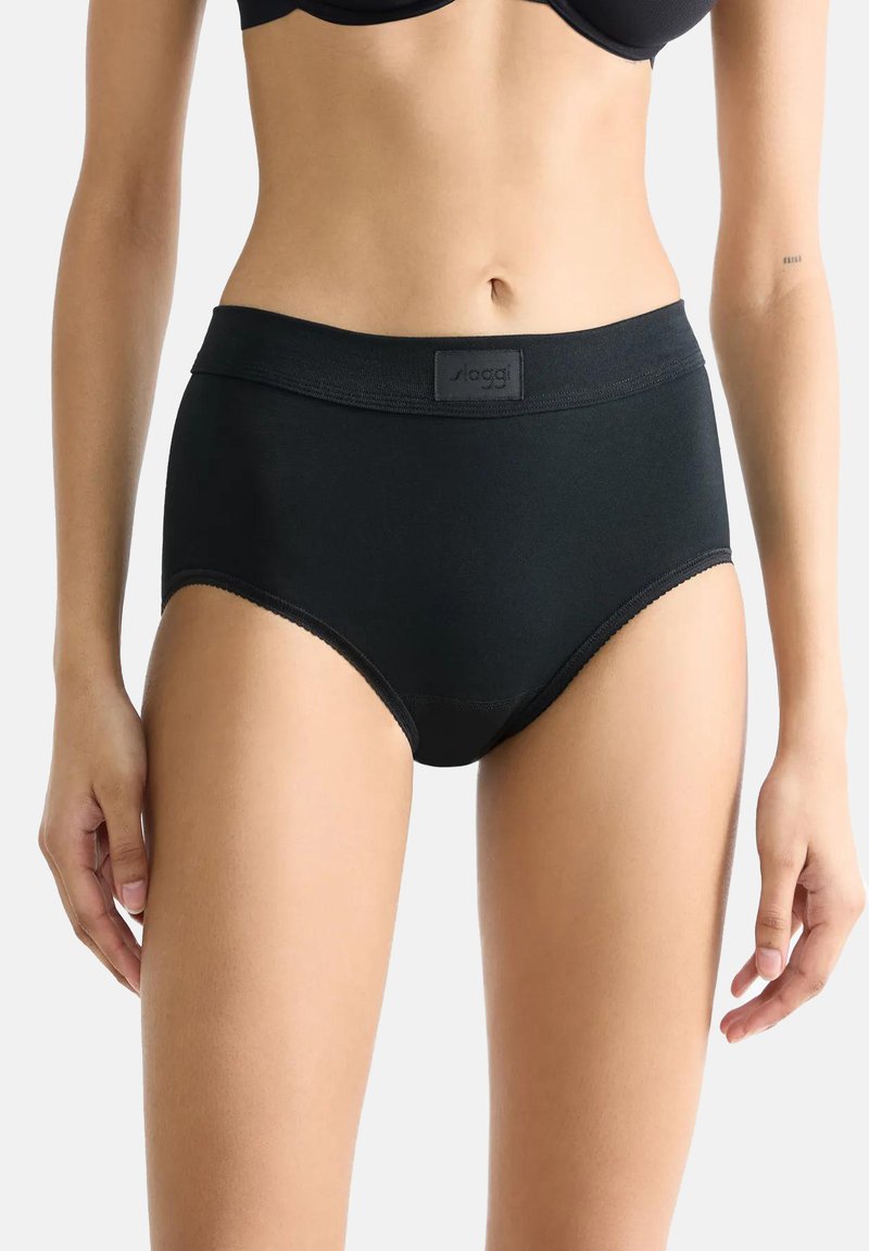 Zwarte high-waisted slip gemaakt van zacht, rekbaar materiaal. Kenmerkt zich door een brede elastische tailleband met een logolabel en een naadloze rand.