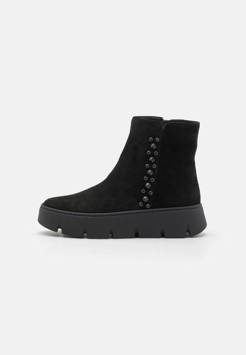 Bottines en suède noir avec une semelle épaisse noire et des accents décoratifs en perles sur le côté. Texture lisse et design ajusté.