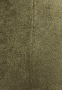 Tissu texturé vert olive avec une finition douce, présentant un design sans couture et une couture verticale au centre pour un détail structurel.