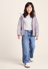 Gray quilted puffer jacket, white t-shirt, high-waisted denim jeans, and white sneakers with brown accents. Boyish fit and casual style.