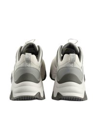 White and gray athletic shoes with a textured upper, padded collar, and an elevated heel. Features a pull tab at the back and patterned outsole.