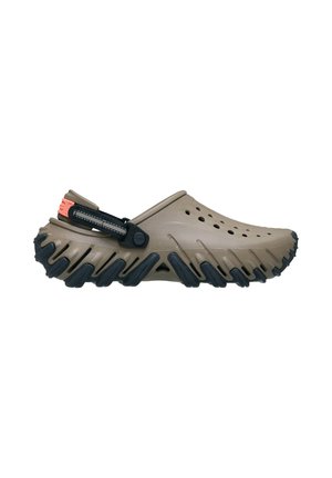 Brauner Slip-on Clog mit schwarzer, strukturierter Sohle, Belüftungslöchern oben und verstellbarem schwarzem Riemen mit orangefarbenem Detail an der Ferse.