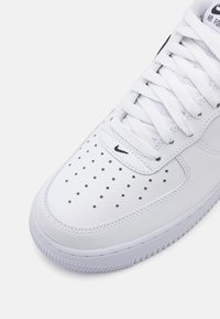 Balti ādas tenisi ar perforētu apdari, plakaniem apaļiem šņorēm un mazu melnu logo sānos. Gumijas zole ar teksturētu saķeri.