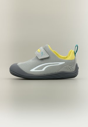 Gray athletic shoe with a velcro strap, yellow lining, teal pull tab, and white side detail, shown in profile on a neutral background.
