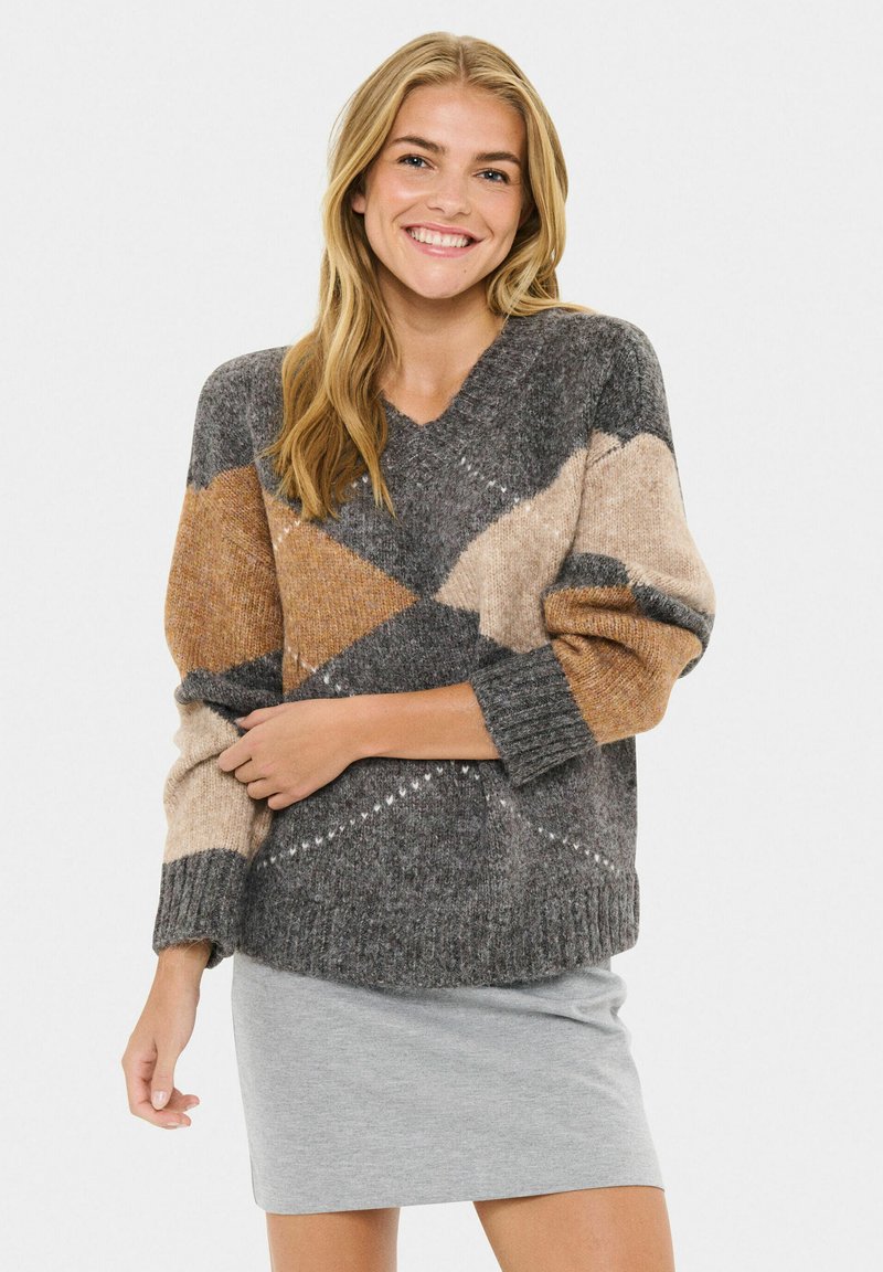 Pullover mit V-Ausschnitt, der ein graues, beige und rostfarbenes geometrisches Muster aufweist, mit gerippten Bündchen und Saum, getragen über einem grauen Rock.