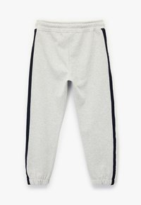 Pantalones de chándal grises con cintura elástica, que cuentan con rayas laterales en azul marino oscuro y puños elásticos en los tobillos. Material de suave mezcla de algodón.