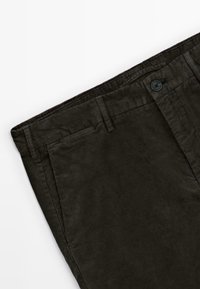 Pantalons en velours côtelé vert foncé au design à jambes droites, dotés de passants de ceinture, d'une fermeture à bouton et d'une texture subtile grâce au tissu côtelé.