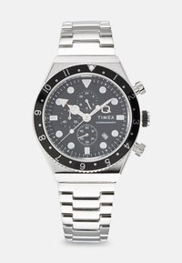 Orologio cronografo Timex con quadrante nero, cinturino in acciaio inossidabile argentato, cassa rotonda, marcatori delle ore prominenti e indicazione della data a ore 6.