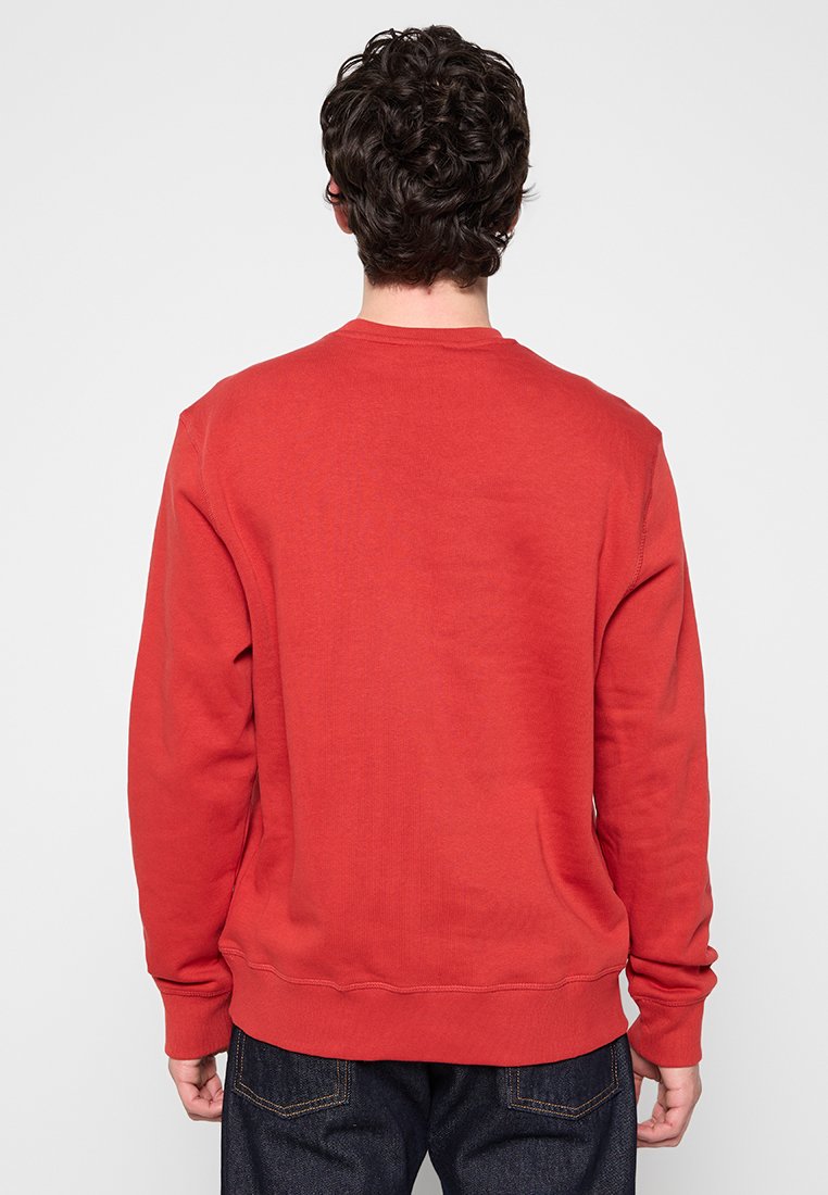 Felpa rossa con collo rotondo, maniche lunghe e polsini a coste. Realizzata in tessuto morbido, presenta un design semplice senza loghi visibili.