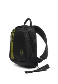 Zaino nero realizzato con un tessuto liscio e resistente, caratterizzato da un logo verde ben visibile, numerosi scomparti con zip e una tracolla imbottita e testurizzata.