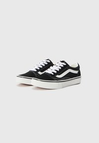 Schwarze Canvas-Sneaker mit niedriger Schafthöhe, weißen Schnürsenkeln, weißen Seitenstreifen und weißen Gummi-Sohlen. Mit gesteppten Akzenten entlang der Kanten.