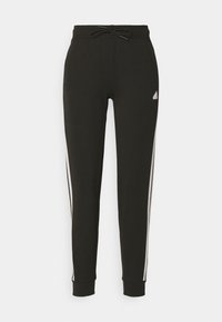 Pantalones de chándal negros hechos de material suave, con cintura ajustable, piernas cónicas y franjas laterales blancas. Incluye un logo en forma de triángulo en la cadera.