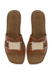 Sandali piatti marroni con accentuazione beige intrecciata, dotati di cinturini larghi e suola imbottita. Punta quadrata e branding minimal embossato.