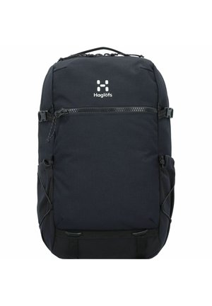 Mochila rectangular negra de Haglöfs con bolsillo delantero con cremallera, bolsillos elásticos laterales, asa superior y correas de compresión en los laterales y en la parte inferior.