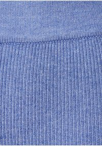 Svijetloplava pletiva sa vertikalnom rebrastom teksturom. Glatka površina s suptilnim varijacijama boje i mekanim osjećajem. Nema istaknutih uzoraka ili detalja.