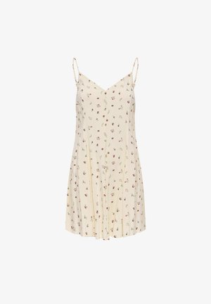 Robe sans manches couleur crème avec fines bretelles, petit motif floral rouge et bleu, boutons à l'avant et décolleté en V.