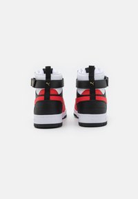 Sneaker alta in pelle nera, con dettagli rossi, una suola bianca e cinturini regolabili. La vista posteriore mostra un colletto imbottito e il logo.