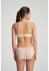 Light pink bra and brief set made of smooth fabric. The bra features decorative straps and a hook-and-eye closure at the back.
