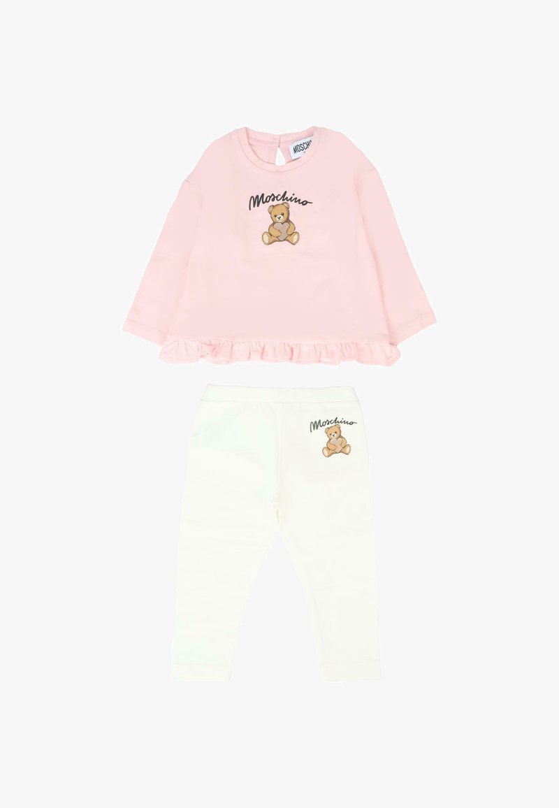 Roze langetermijnhemd met een rimpelzoom en teddybeerprint, gecombineerd met witte leggings met bijpassende teddybeeraccenten en logo.