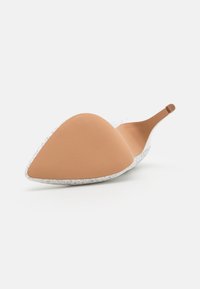 Biele špicaté topánky na podpätku s textúrovaným zvrškom, hladkým telovým vnútrom a úzkym podpätkom. Má elegantný siluet a minimálne dizajnové prvky.