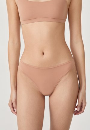 Beżowa, gładka bielizna bikini o niskim kroju, wykonana z miękkiego materiału, o minimalistycznym designie. Bez widocznych szwów i ozdób.