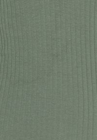 Grön ribbad tyg med vertikala ränder, tillverkad av mjuk, texturerad bomullsblandning, vilket ger ett lätt och andningsbart utseende.